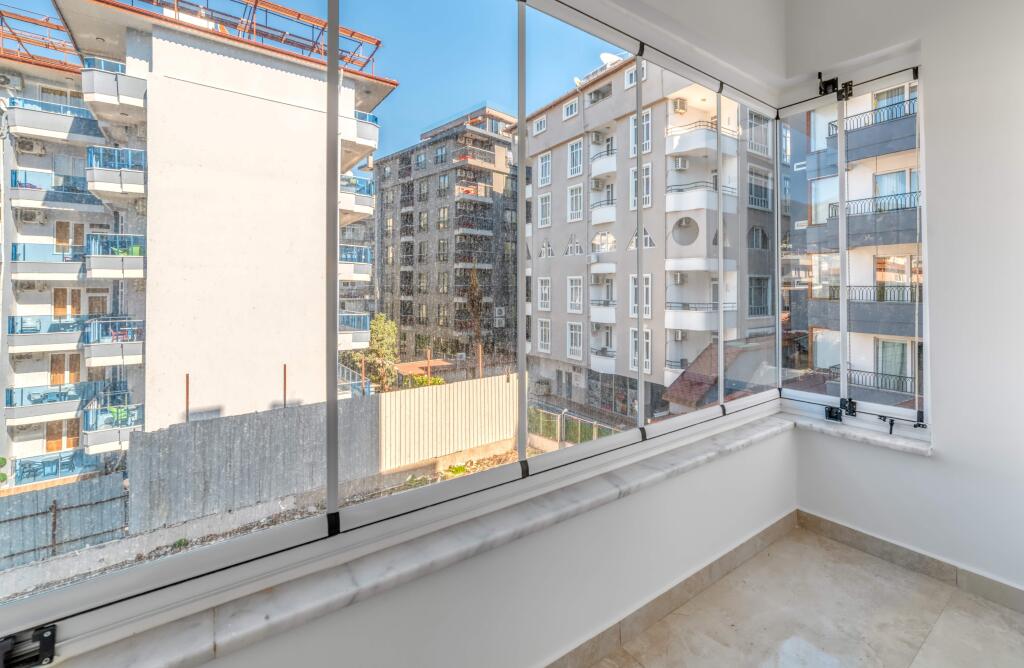 Apartman balkonlarında kapalı cam sistemleri yer alıyor