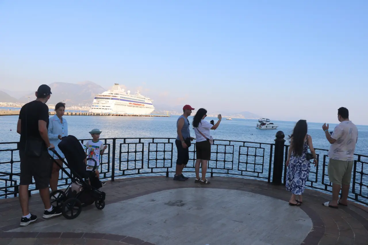 Alanya sahilinde turistler gemiyi izliyor