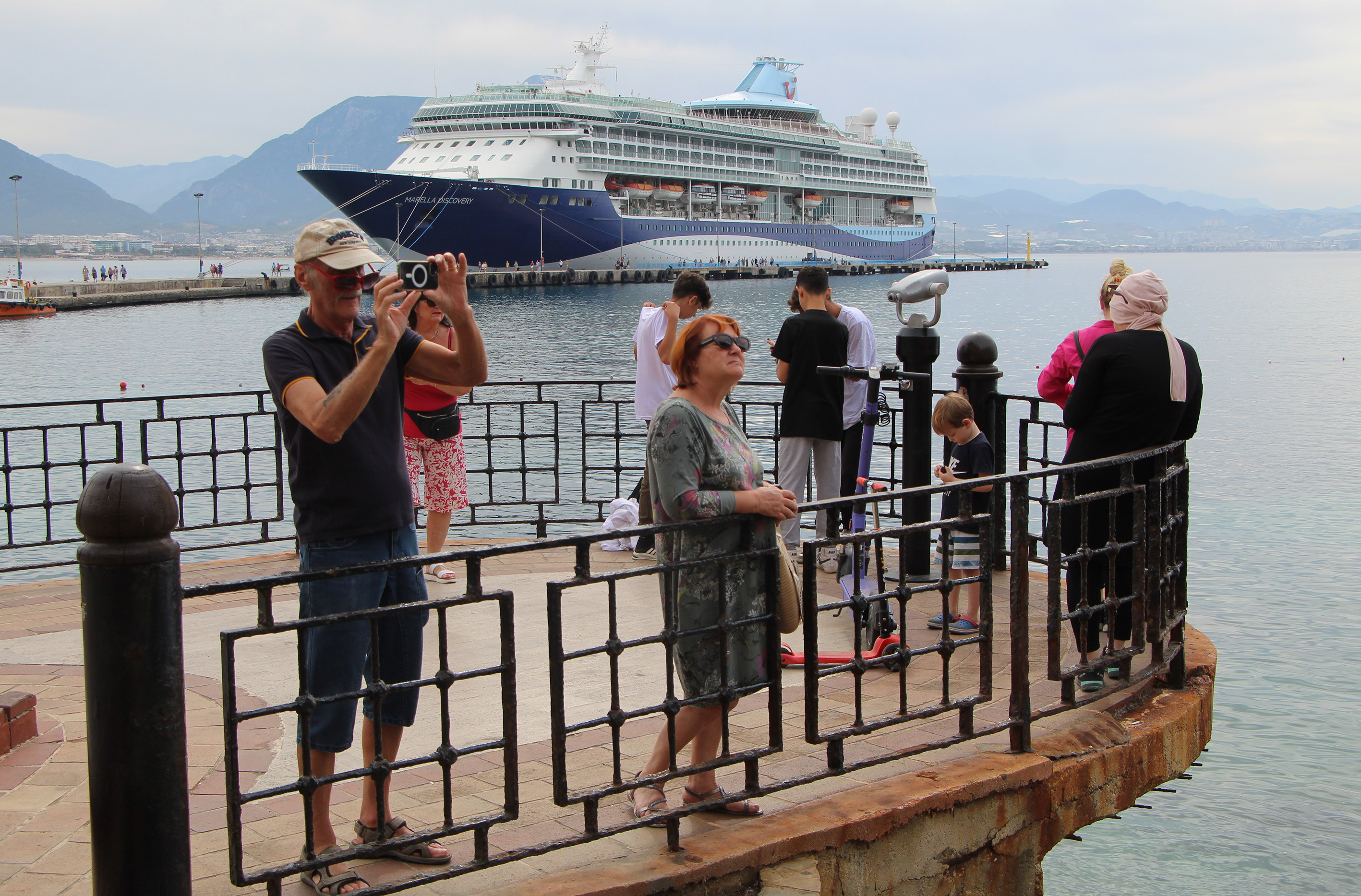 Alanya Limanı’nda turistler gemiyi görüntülüyor