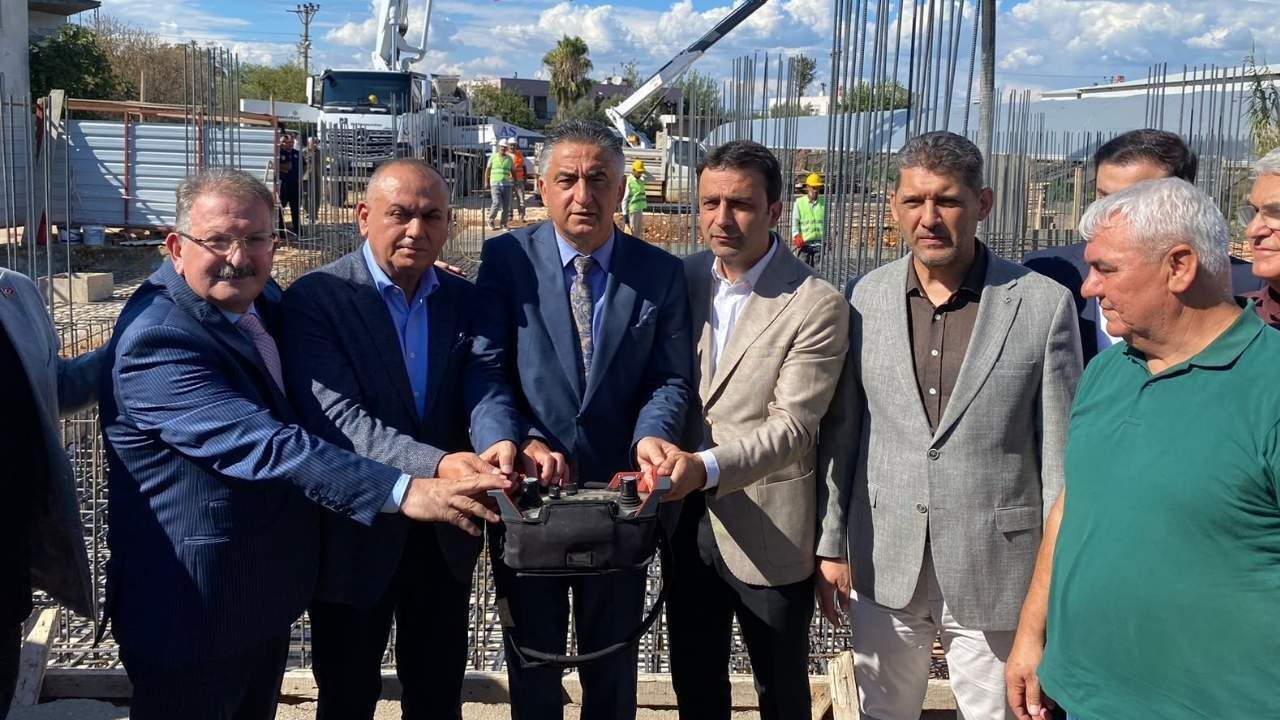 Temel atma töreninde katılımcılar ilk beton dökümü için bir arada